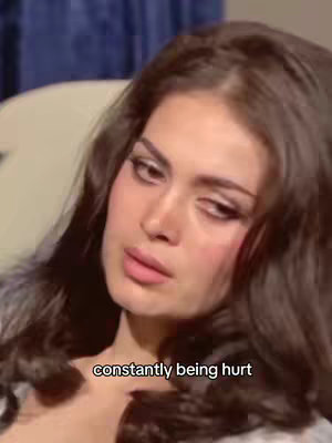 A close-up of a woman's face. She has long, dark hair and is wearing makeup. The image has a vintage-style aesthetic, with soft lighting and a slightly blurred quality. Text overlay at the bottom.