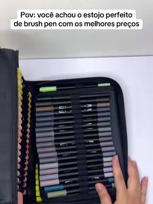 The image showcases an open pen case filled with various colorful brush pens. The pens are neatly arranged, with various shades discernible. The case is shown open, revealing the pens, and the scene is shot from a slightly overhead angle. Some text is also present at the top.