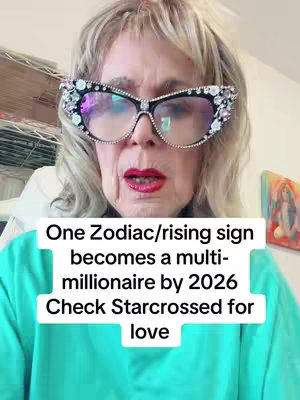 The cover image showcases a person with a close-up shot from the chest up. The background is filled with an indoor setting, with a glimpse of shelves and furniture on the left and a framed picture on the right side of the screen. The person has light-colored hair, red lips and is wearing large bejeweled glasses. The person is facing forward with their mouth slightly open. The overlay text is on a rectangular shape, which has a mint green background.