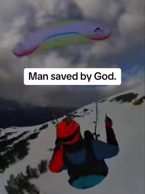 The cover image shows a split screen. The top half depicts a paraglider wing with a rainbow color scheme against a cloudy sky. The bottom half features a person on a snowy mountain slope with a red helmet and blue jacket. Text overlay states: Man saved by God.