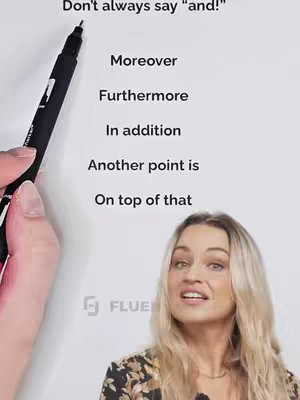 A woman is presenting a lesson on English grammar, using a white board with text on it. The woman has long blonde hair and is wearing a floral top. A black pen is being held over the text.