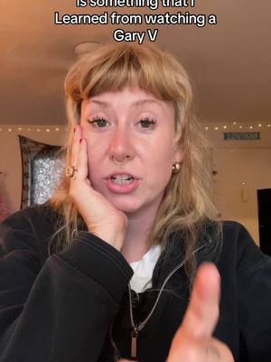 A woman with blonde hair and a fringe looks directly at the camera with a hand on her cheek; text overlay. She is wearing a black zip-up hoodie and a white shirt underneath. The background suggests a domestic setting.