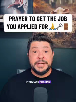 A man with a beard is centered in the frame, looking directly at the camera. Above him is a white text box with the words 'PRAYER TO GET THE JOB YOU APPLIED FOR,' followed by prayer hands, a key, and a door emoji. The background contains framed images or art pieces with natural and religious themes.