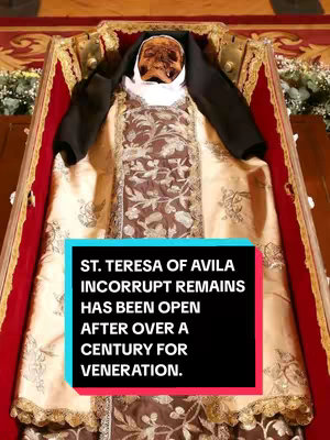 The image shows a close-up of a relic, possibly a preserved human form, within an ornate red and gold display case. A text overlay highlights a historical event related to St. Teresa of Avila.