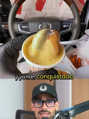 A photo shows a person in a black cap and glasses holding a cup of food in front of the driver's seat. The food looks like a scoop of yellow mush. The video's hook text is in the yellow section against the background. The man is smiling and looking at the camera, with the gear shift and steering wheel in the background.