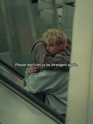 Two people embracing on an escalator. The lighting is soft, with a slightly muted color palette. The overall composition is focused on intimacy and closeness, with a subtle, romantic atmosphere.