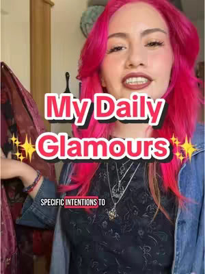 A woman with bright pink hair is looking directly at the camera; text overlays state "My Daily Glamours," with spark effects. She wears a dark top and a blue denim jacket, around her neck are layered necklaces.