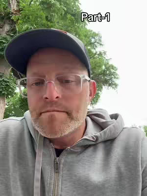 A medium shot shows a man from the chest up, wearing glasses and a cap. The background features a blurred canopy of green trees. The man has a neutral expression. Overlayed on the top right corner of the image is the text 'Part-1' in white letters.