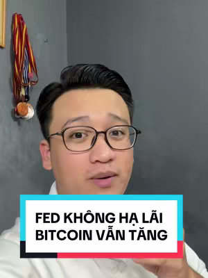 The cover image shows a man in a selfie-style shot. He is wearing glasses and looking directly at the camera. The background is a plain, dark gray wall. At the bottom of the image, there is a colored bar with text written on it.