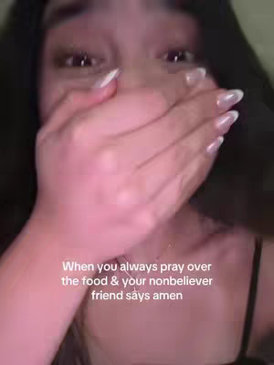 A close-up shot focuses on a woman's face as she covers her mouth with her right hand. The woman has long, dark hair. Text at the bottom of the image reads 'When you always pray over the food & your nonbeliever friend says amen.'