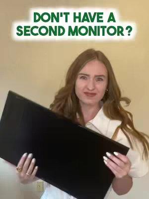 A woman with long, wavy brown hair is holding a black monitor in front of her. She is wearing a white shirt and has a slightly surprised or questioning facial expression. The background is a light beige wall.  A word overlay is at the top with text in white outlined by a green border.