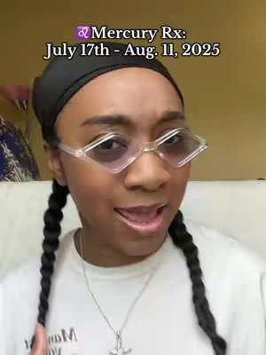 A selfie-style shot of a young woman with dark hair in braids, clear-framed diamond-shaped glasses, and a black head covering. Text overlay at the top indicates an astrological theme.