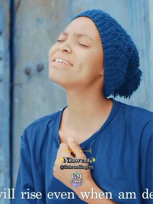 A person with a blue knit cap and a blue shirt is holding a hand to their chest. Their eyes are closed, and their head is tilted upwards, and a text overlay with the words "Nitaweza" and the name of the musical artist, "Zabron Singers".