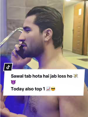 A man in a pool area, shirtless, holding a phone to his ear and looking off to the side. The background shows a pool, tiles, and a doorway. A text overlay appears at the bottom of the screen.