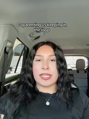 A woman with long dark hair sits in the driver's seat of a car, facing forward and speaking. She has a necklace on and appears to be recording herself. A text overlay at the top reads, "Coparenting vs keeping in the loop".