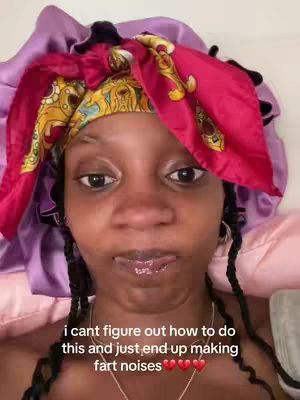 A close-up shot of a Black person's face, their head partially turned away from the camera.  They have dark eyes and the skin is visible. They are wearing a head wrap.  Below the person, a text overlay.