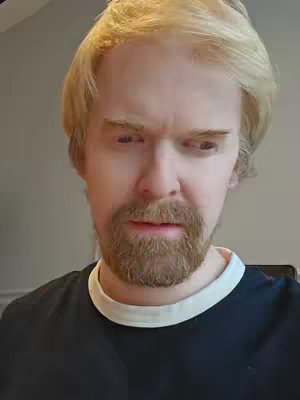 The cover image features a close-up of a man with fair skin, blonde hair, and a neatly trimmed beard looking downwards. He is wearing a dark, crew-neck shirt with a white trim around the neckline. The lighting seems to be natural, highlighting the man's facial features. 