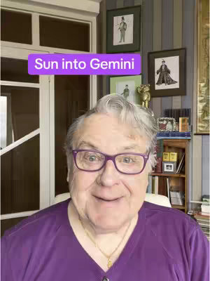 A light-skinned, older man with gray hair and glasses smiles at the viewer, set against a background with a window, framed pictures and a shelf. The text overlay reads 'Sun into Gemini'. He is wearing a purple shirt, and the lighting indicates a daytime setting.