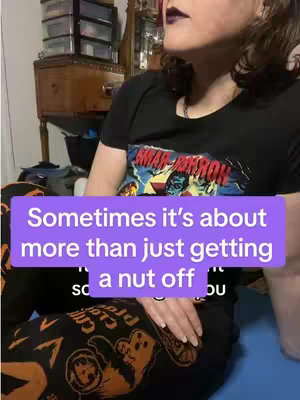 The cover image shows a person sitting down indoors, angled from about the chest up. The person has dark hair and dark lipstick. They’re wearing a black t-shirt that appears to have a graphic on it. They have a lilac rectangle overlaying them that contains white text. The background consists of a wooden dresser, and other furniture.