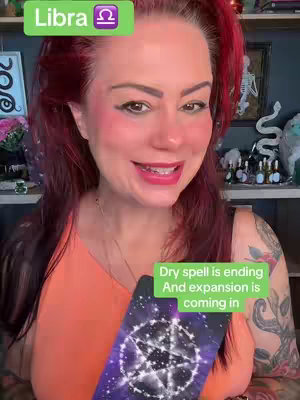 A woman with red hair and an orange top is holding a tarot card with a purple and silver design. A green rectangle with the word 'Libra' and a Libra symbol is in the upper corner, and another green rectangle on the right displays text. The background is a room with shelves and various items.