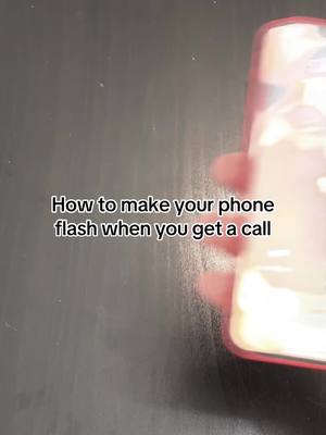 The cover image shows a phone held in a hand, partially obscuring the view. In the background, the surface appears dark. Overlayed text provides a tutorial about how to get your phone to flash when there's a call.