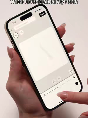 A person is holding an iPhone displaying a screen with a white background with some icons and a screen that might be the content shown in the background. The phone is held in a slightly tilted position. The primary color of the surrounding is white and there are some finger nails being added to the scene.