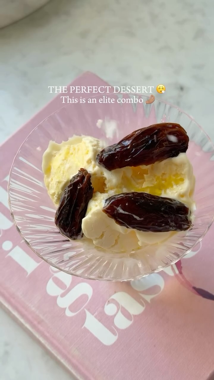 The cover image shows a close-up of a dessert in a glass bowl. There are scoops of vanilla ice cream, olive oil drizzled on top, and several dates arranged on the ice cream. The bowl sits on a pink book. The text overlayed on the image reads: "THE PERFECT DESSERT 🥺 This is an elite combo 🤌🏽".