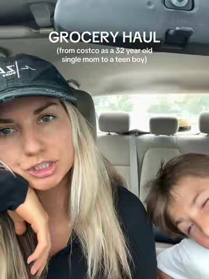 A woman with long blonde hair is seated in a car, looking at the camera and talking. Text overlays the video, revealing her to be a "single mom to a teen boy." Next to her, partially visible, is a teen boy. They are seated in the front seats of a car. The background features a glimpse of the car's interior.