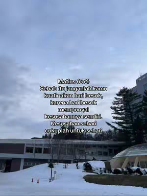 An outdoor shot showing snow on the ground in front of a building with a cloudy sky background. A block of text is overlaid on the image containing a quote from Matthew 6:34.