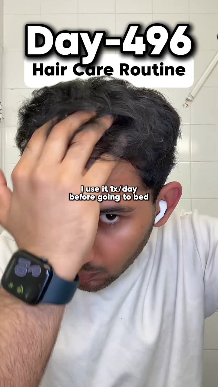 A man with dark hair is shown close-up, his hand touching the top of his head. The image is well-lit, and he appears to be in a bathroom. Text overlays the top of the frame, indicating the video's subject, and a second line of text at the bottom provides additional context.