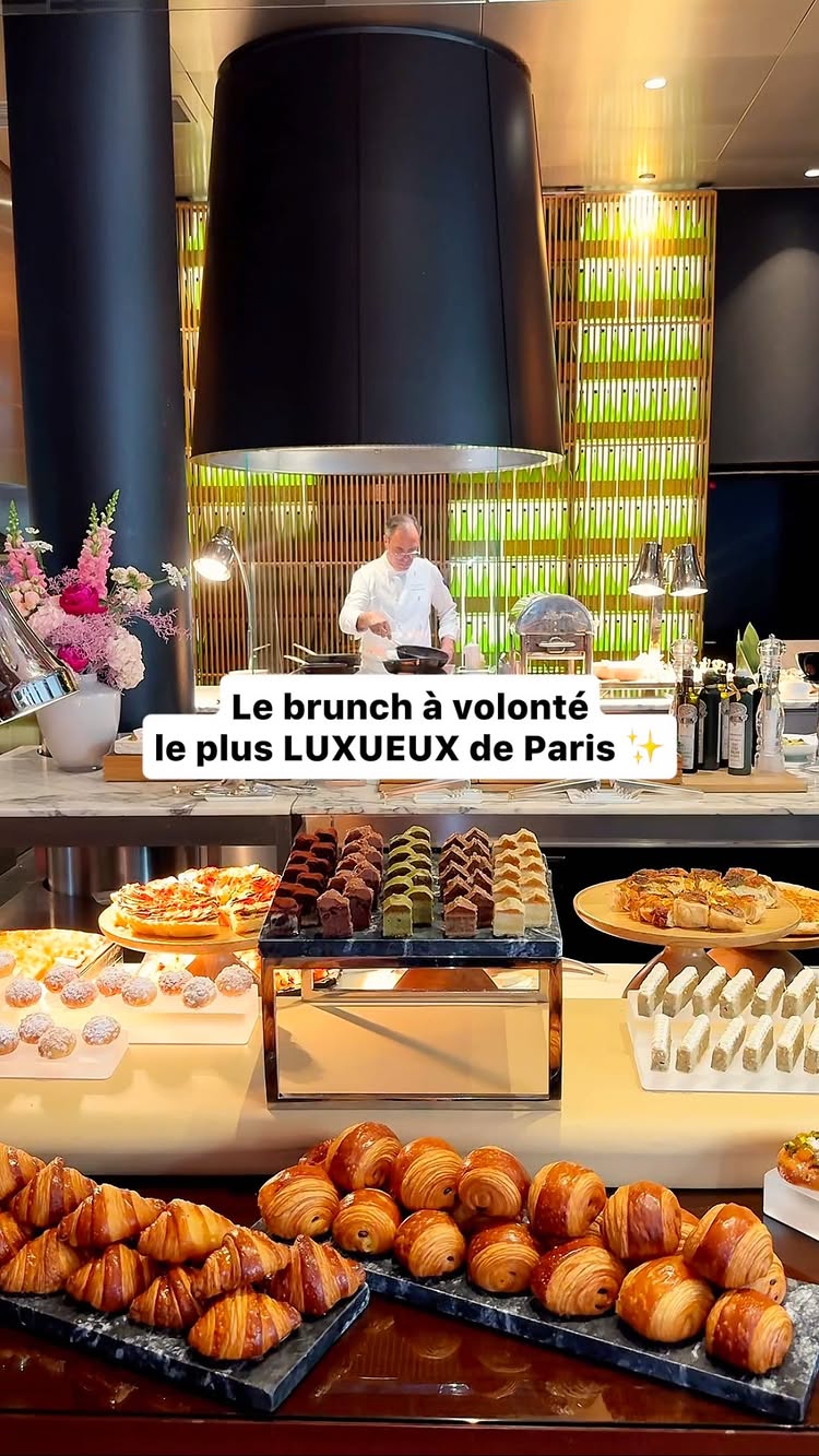 The cover image features an array of freshly baked croissants, pastries, and various food items on display at a brunch buffet in a luxury setting. A chef is seen in the background. The text overlayed reads "Le brunch à volonté le plus LUXUEUX de Paris", (the most luxurious brunch in Paris). The overall impression is one of elegance and indulgence.