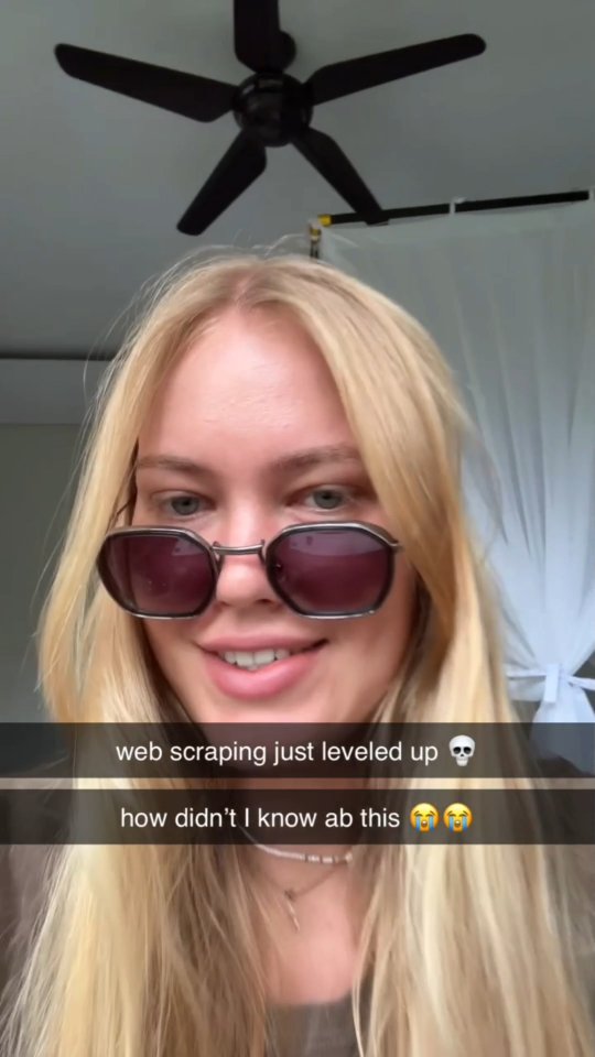 A selfie-style shot featuring a young woman wearing sunglasses. The background includes a ceiling fan and a partially visible window or curtain. The woman is smiling, and text overlays are present with a skull emoji and crying face emojis, alluding to excitement.