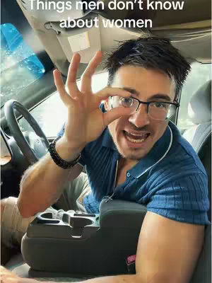 A man with glasses is inside of a car. The man is holding his left hand up in front of him and is pointing towards the lens of his glasses using his index finger. He has his mouth open and seems to be talking. The driver's side car window is in view. The man appears to be making a gesture. The title of the video is at the top of the image.