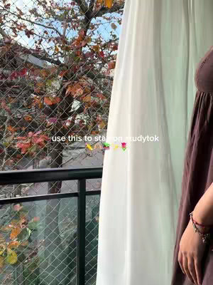 The cover image features a window view with a chain-link fence and a tree with red and yellow leaves in the background. The foreground includes a white curtain and a portion of someone wearing a brown dress with a bracelet on their wrist. The text overlay reads "use this to stay on studytok" with colorful emojis.