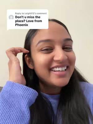 A woman with dark hair is smiling at the camera, with a comment box at the top-left, showing a comment about the plaza and a love message from Phoenix. The background is plain.