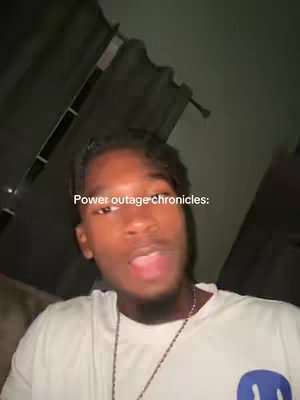 A selfie-style video with the creator in the foreground, partially lit with what appears to be indirect lighting, likely indoors. The image has a dark background with some visible structure or texture. Light text overlaying the image.