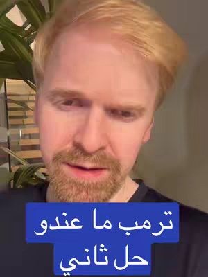 A close-up shot of a fair-skinned man with red hair. He is looking down and slightly to the side, with an expression of concern or thought. Below him, there is a dark blue rectangular text overlay with white text in Arabic.