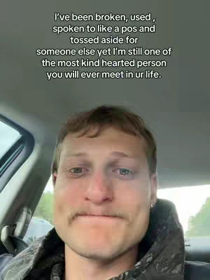 The image shows a man looking at the camera with a melancholic expression, while sitting in a car. Text is overlaid regarding feeling broken and yet being kind-hearted.