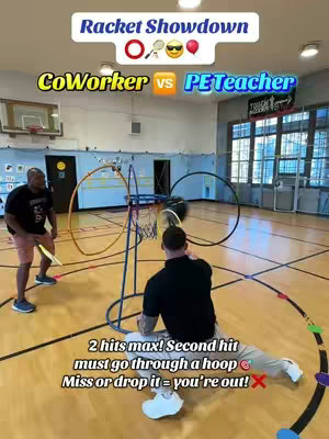 The image shows a gymnasium setup for a racquet game with two figures in athletic attire. The play area includes a hoop, a basketball hoop, and a floor marked with lines. Overlay text indicates a competition format: 'Racket Showdown', with 'CoWorker' versus 'PE Teacher'. Additional text details the game’s rules: two hits maximum, second strike through a hoop, or they are out. The primary colors are the gym's wood, the players' clothes, and the game's setup.