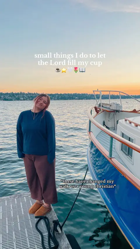 A young woman stands on a dock next to a boat, smiling at the camera, with water and a sunset in the background. Text overlays indicate the theme is Christianity.