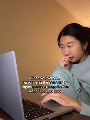 A woman is sitting in front of a laptop, the screen tilted towards her. She wears a light blue top. A text overlay provides context.