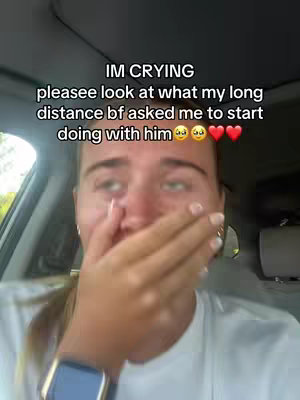A woman in a car, covering her mouth with her hand. The text overlay reads "IM CRYING pleasee look at what my long distance bf asked me to start doing with him"