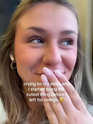 A close-up shot of a young woman with blonde hair and blue eyes. She is in the foreground, with her right hand covering her mouth. Text overlayed on the image reads a caption about crying because of her sister and leaving for college.