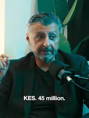 A man with graying hair and business-casual attire sits in a studio with a microphone. The background features a green plant. On the bottom of the image, the text overlay displays "KES. 45 million."