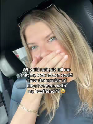 The cover image shows a woman smiling slightly with one hand covering her lower face. She has long blonde hair with dark sunglasses on top of her head, and she is in front of a car interior.