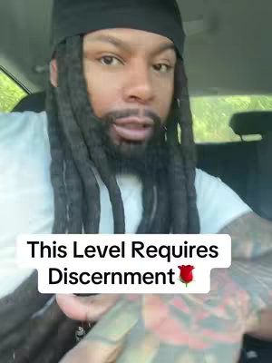 A man in a white t-shirt and black durag is sitting in the front seat of a car. The hook text says 'This Level Requires Discernment' with a rose emoji.