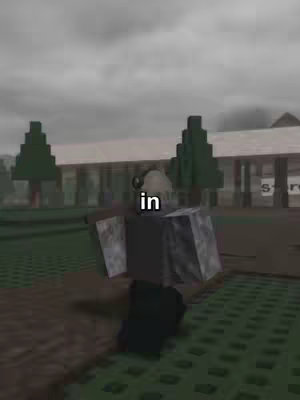 A screenshot from a Roblox game. In the foreground, a person or avatar is visible in a pixelated setting with a grey and black color scheme. The background appears to be a daytime outdoor environment with a pixelated building, green trees, and a white sign. The sky is overcast. The text "in" is overlaid on the scene.