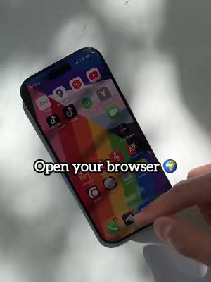 An iPhone rests on a light-colored surface against a neutral background. The phone's screen displays an app setup with a rainbow-colored background and various app icons. A finger is touching the screen's interface. Text overlayed indicates a call to action.