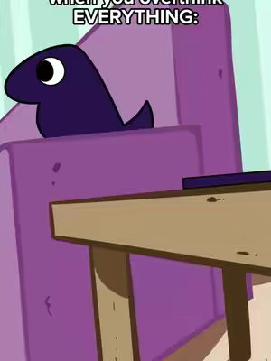 An animated character, dark purple and blob-like, sits in a purple chair against a background with more purple and a wooden surface. Text overlays appear at the top.