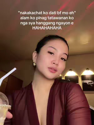 A medium shot of a young woman with long dark hair, wearing a deep red sheer top, holding a clear cup with a straw. She is looking slightly off-camera with a nonchalant expression. Soft lighting highlights her face, and text in white is overlaid above her head.